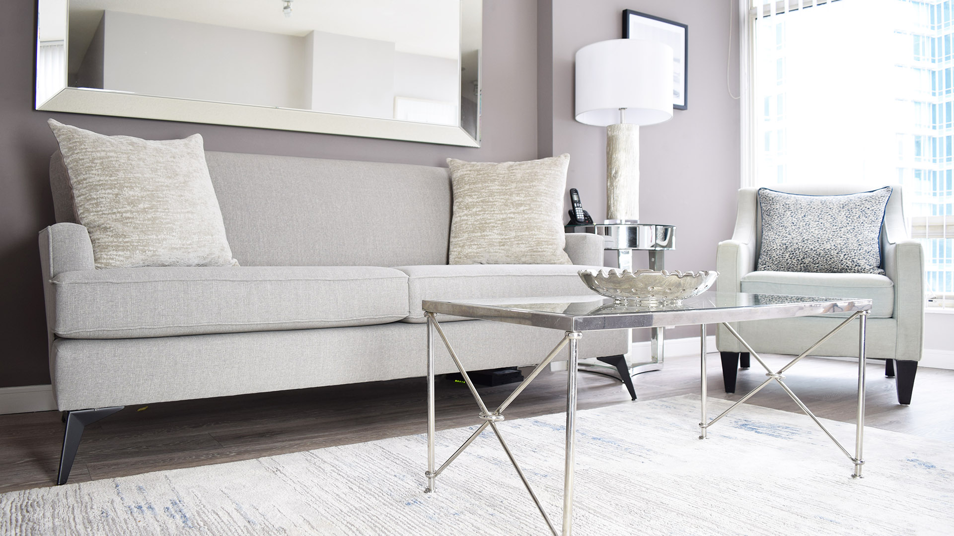 Grey sofa with accent pillows in the living room of apartment 1401-1288 Alberni St. at the Palisades.