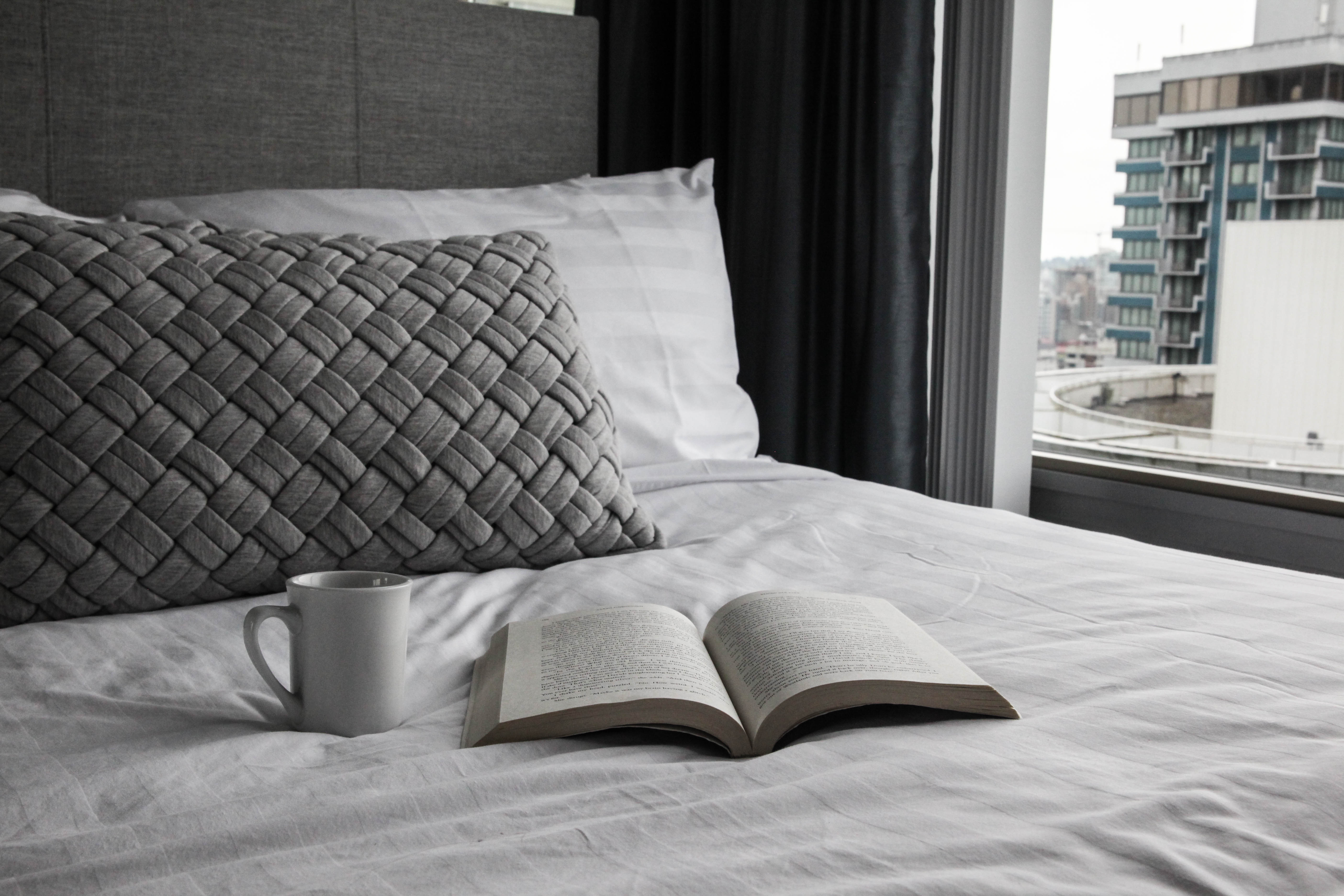 book and mug on the bed at Vancouver Extended Stay